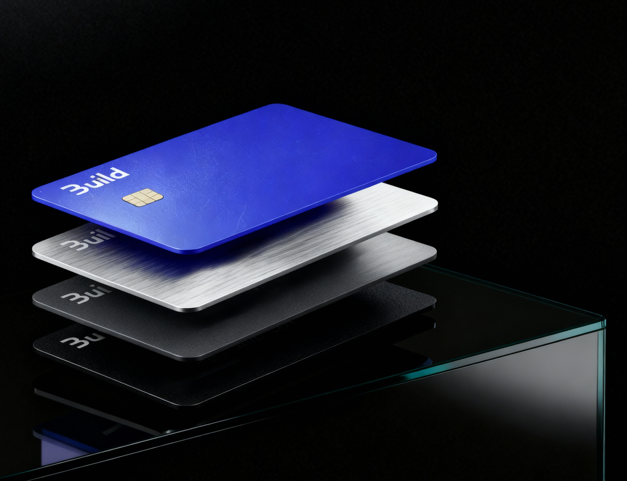 Three Build cards — blue, brushed metal and matte black — stacked on glass
